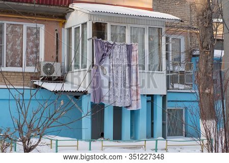 Lingerie Dries In Winter On A Rope On The Street, A Blue House, Bushes