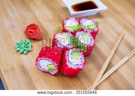 Japanese Sushi Food On A Wooden Board. Salmon, Rice, Wasabi, Ginger, Chopsticks Hashi Japanese Cuisi