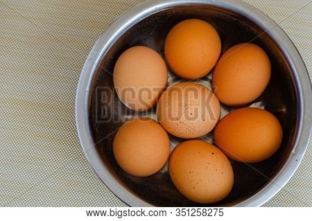 Seven Boiled Chicken Eggs In A Metal Bowl. In A Stainless Steel Bowl, Freshly Boiled Chicken Eggs Ar