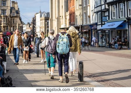 Cambridge, Uk, August 1, 2019. Turists Walking Down Using A Pair Of Antishock Hiking Sticks Or Walki