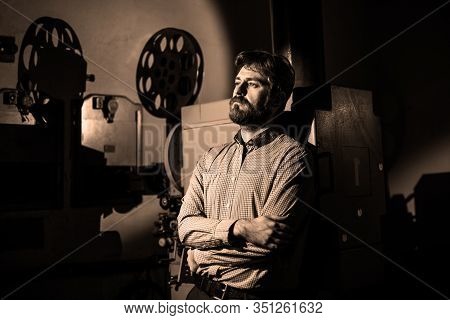 Beautiful Hipster Man Standing Near A Film Projector In The Room Projectionist