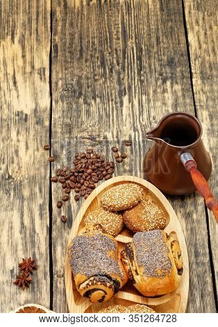 Coffee Beans Are Scattered On An Old Wooden Table Next To Dried Slices Of Orange, Anise Stars, Next 