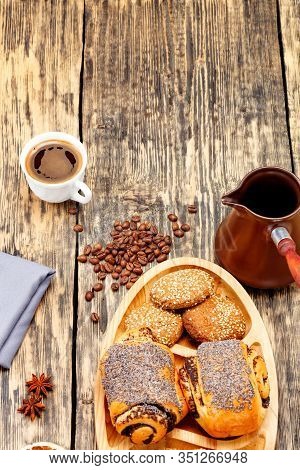 Coffee Beans Are Scattered On An Old Wooden Table And Freshly Brewed Coffee In A White Porcelain Cup