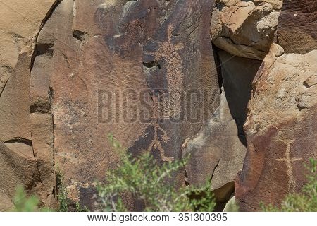 Ancient Petroglyphs Of  Man Like Figure Are Carved Into Sandstone Rocks Which Are Cracking And Break