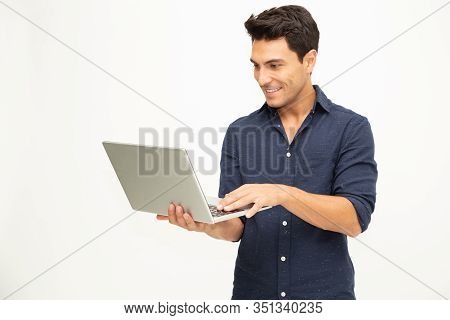 Portrait Of An Excited Man Holding Laptop Computer And Celebrating Success Over White Background, Ra