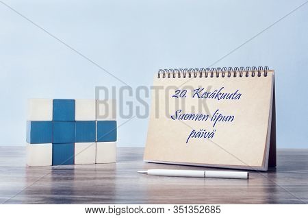 Congratulations On The Day Of The Finnish Flag. On The Table Is A Finnish Flag And A Notepad That Sa