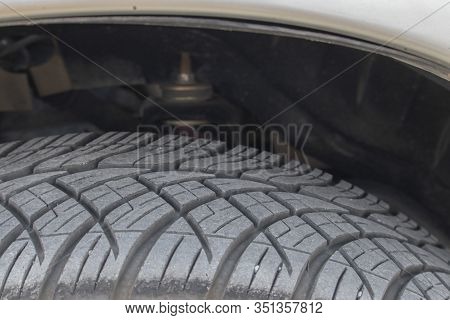 Blur And Noir Close-up. Black Tires Have Small Pebbles And Sand On The Surface. In The Grooves Of Th