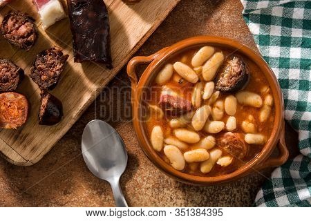 Typical Spanish Fabada Asturiana In Crockpot On Wooden Table. Top View