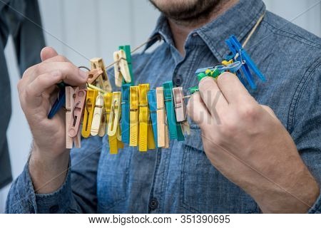 Portrait Of A Man About 30 Years Old With A Beard, Hangs His Clothes On A Clothesline, Leads A Bache