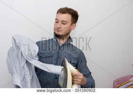 A Man Of About 30 Years Irons His Clothes With An Iron, Leads A Bachelor Lifestyle, Is Going To Visi