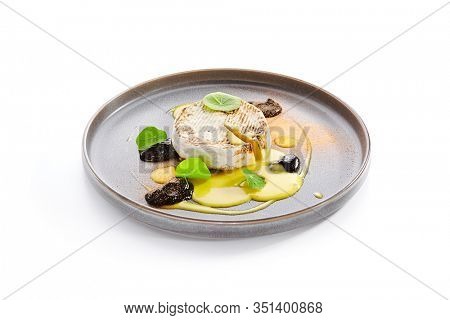Baked Camembert in plate. Served melted cheese in white rind close up. Restaurant gourmet food, appetizer. French cuisine. Creamy soft cheese round chunk. Cow milk dairy product portion