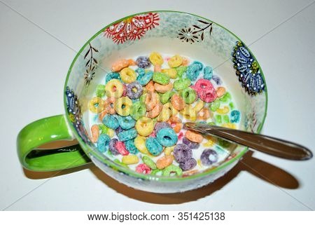 Close Up Of A Bowl Full Of Fruit Flavored Loops Of Sugar Ready To Eat Breakfast Cereal With A Spoon