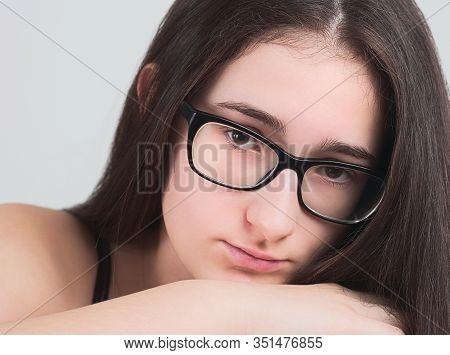 Portrait Of A Serious Bespectacled Long-haired Brunette Teen Girl