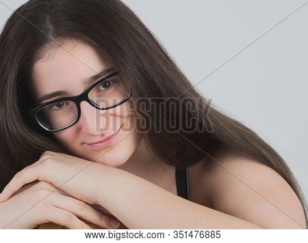 Portrait Of A Smiling Bespectacled Long-haired Brunette Teen Girl