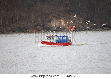Fisherman Boat On The Way To The Fishing Grounds In The Sea Is Followed By Hungry Seagulls