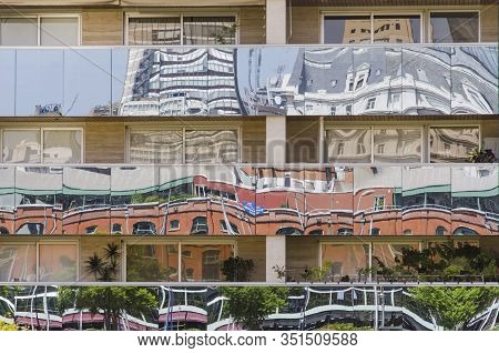 Building With Reflective Glazed Strips That Reflect, Deformed, The Surrounding Buildings, In The Exc