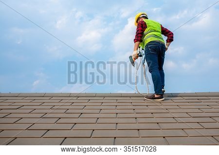 Construction Workers Fixing Roof Tiles, With Roofing Tools, Electric Drills Used On Roofs In Safety 