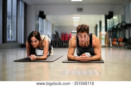 Two atheletes doing push ups in a gym
