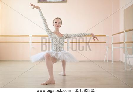 A Very Flexible Ballerina In A Tutu Stands In A Plie In A Class With Ballet Machines. Incredibly Pla