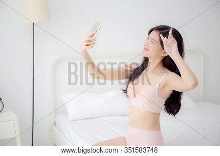 Beautiful Young Asian Woman Sexy In Underwear Talking A Selfie On Smartphone For Social Network In T