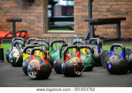 large group of colored kettle bells in gym