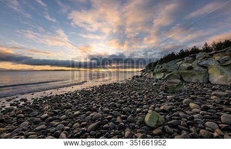 Beautiful Dynamic Sunrise Over The Coast With Dramatic Clouds Over Rocky Beach On Vancouver Island,