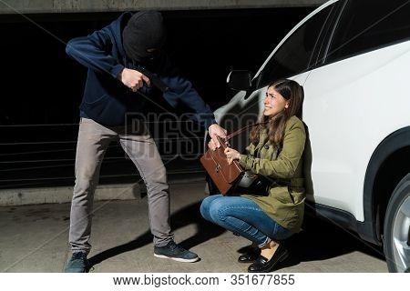 Criminal Robbing Woman Of Her Purse Against Car At Night