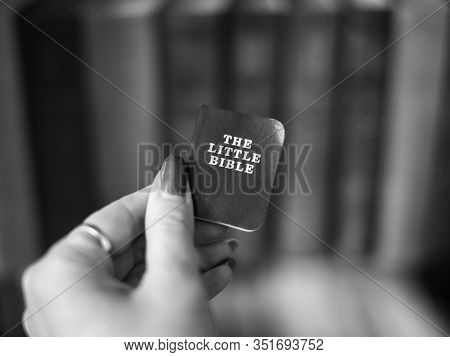Little Holy Bible Book In Girls Hand. Black And White Photo.