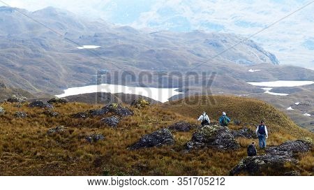 Cajas National Park Close To The Cuenca At Cloudy Rainy Day, Ecuador. Group Of Tourists On The Trail