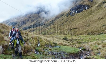 Azuay, Ecuador - December 12, 2019: Tourists On The Hiking Trail In Cajas National Park Close To The