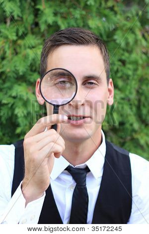 Homme regardant à travers la loupe