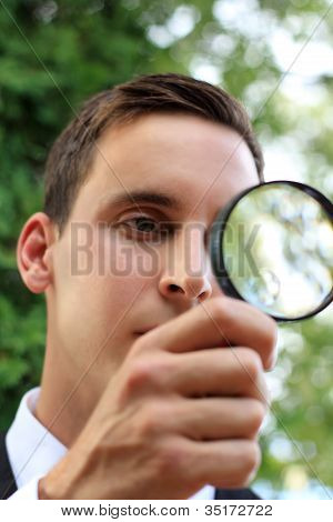 Homme brandissant une loupe