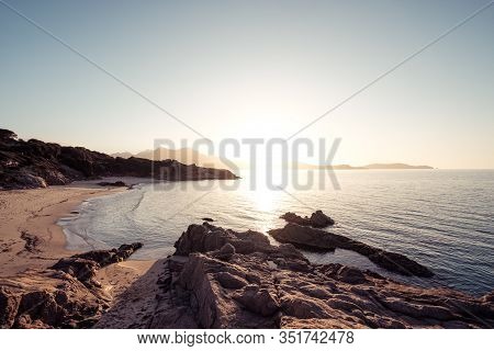 Sun Setting Over The Golden Sand Of Plage De Sainte Restitude Beach In The Balagne Region Of Corsica