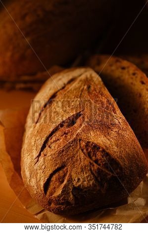 Different Buns Of Fresh Bread On A Brown Vintage Background. Freshly Baked Wheat Bread, Still Life W