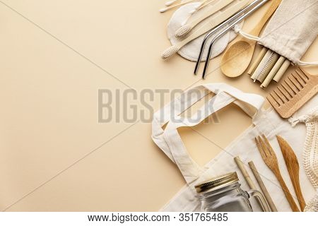 Cotton bag, bamboo cultery, glass jar, bamboo toothbrushes, hairbrush and straws on color background, flat lay.