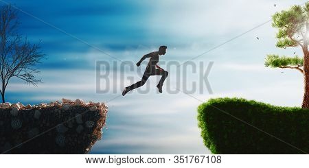 Man Jump Through The Gap Between Hill. Man Jumping Over Cliff On Sunset Background. Business Concept