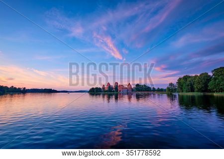 Trakai Island Castle in lake Galve, Lithuania on sunset with dramatic sky reflecting in water. Trakai Castle is one of major tourist attractions of Lituania, now museum and cultural center. Europe
