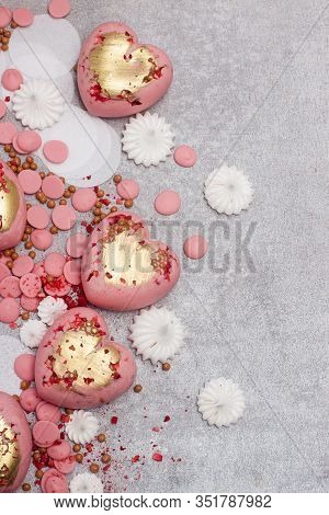Pink Hearts From Tempered Chocolate With Chocolate Drops, Meringues And Dried Berries On Grey Backgr