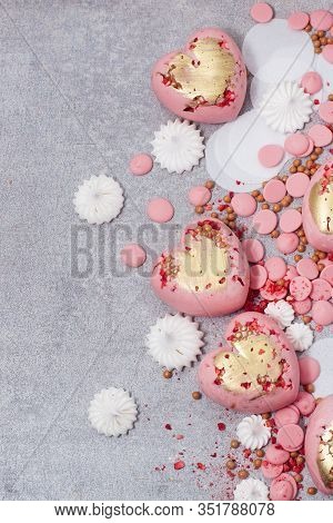 Pink Hearts From Tempered Chocolate With Chocolate Drops, Meringues And Dried Berries On Grey Backgr