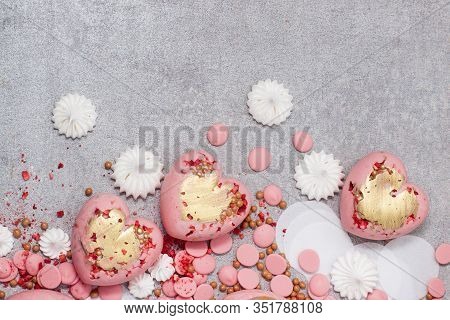 Pink Hearts From Tempered Chocolate With Chocolate Drops, Meringues And Dried Berries On Grey Backgr