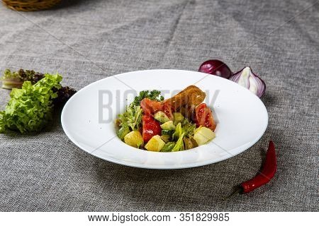 Salad With Black Sea Rapan Meat, Dressed With Honey Sauce. With Rye Crackers. On A Gray Canvas Cloth