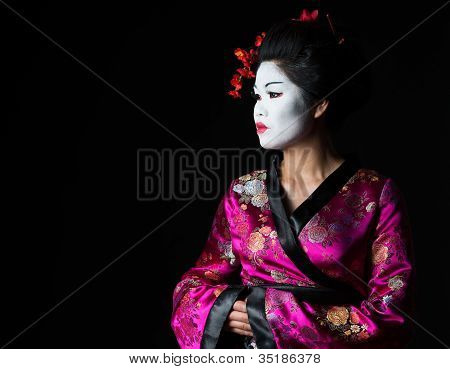 Retrato de gueixa procurando na cópia espaço isolado em preto