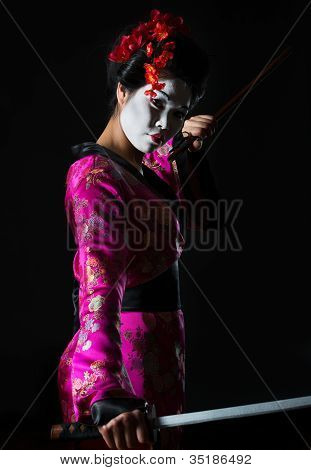 Retrato de gueixa segurando a espada isolada em preto