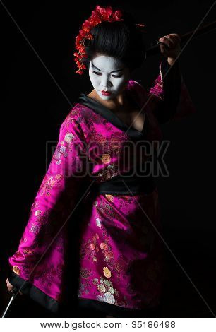 Retrato de gueixa dança com espada isolada em preto
