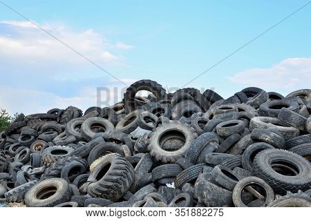 Industrial Landfill For The Processing Of Waste Tires And Rubber Tyres. Pile Of Old Tires And Wheels