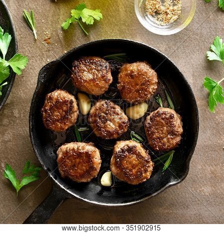Minced Meat Cutlets In Frying Pan Over Brown Background. Top View, Flat Lay