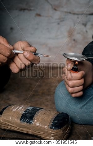 Two Shabby  Men Preparing Drug Injection In Slums.