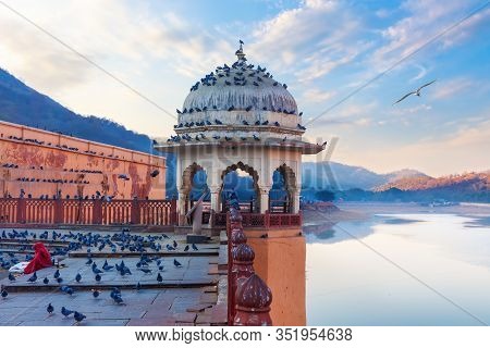 Rotunda Of Amber Fort, Indian Lady Feeding Pigeons By The Maotha Lake, Jaipur, India