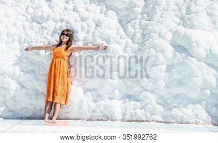 Lady In Orange Dress Posing For Photo At Pamukalle N Turkey With Wide Spread Hands
