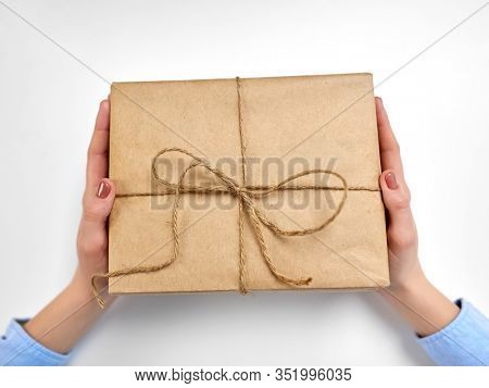 delivery, mail service, people and shipment concept - close up of female hands with eco parcel box tied by rope at post office